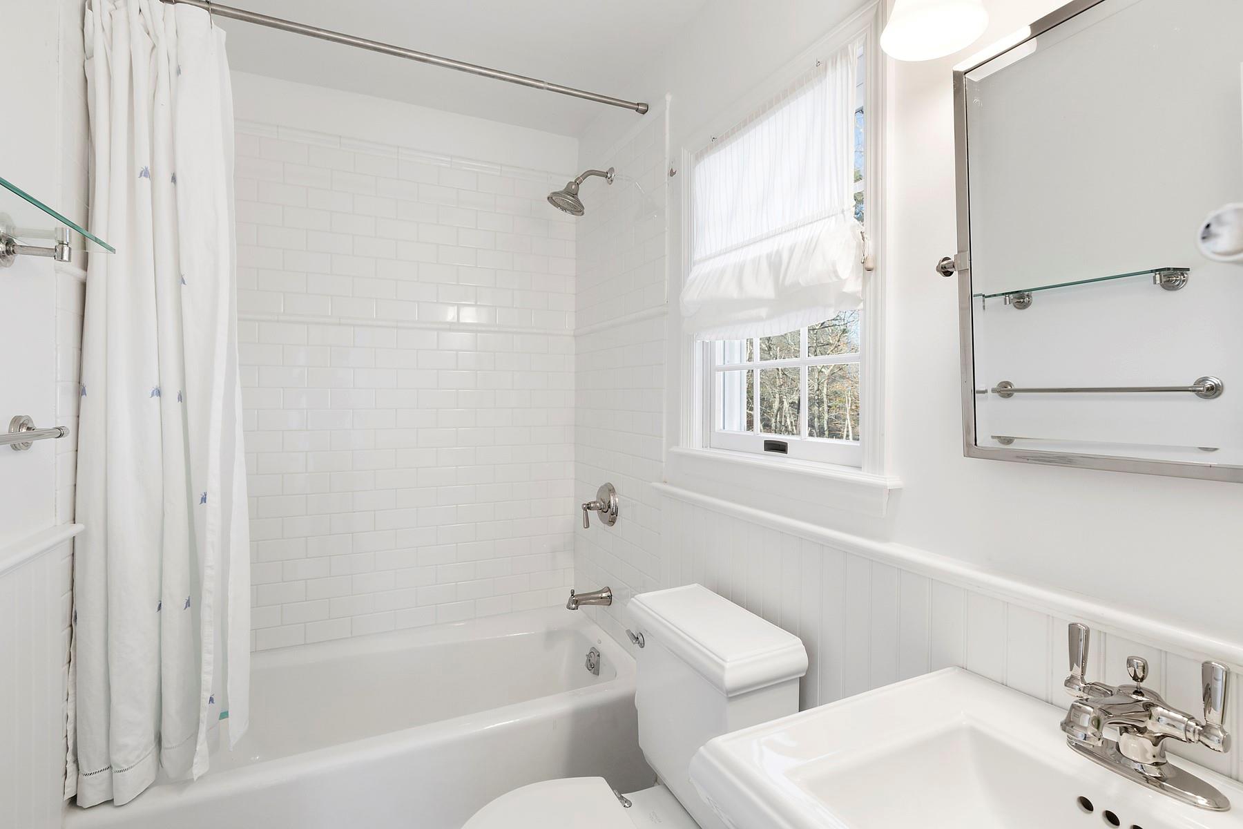 421 Edge Of Woods Road Southampton, NY 11968 - Photo 25 of 33 Full bathroom with shower / bathtub combination with curtain and a wainscoted wall