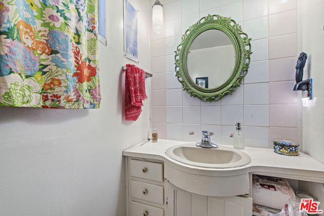 a wooden bench sitting in backside of a house with potted plants and wooden fence