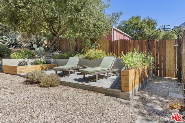 a view of a house with chairs and potted plants