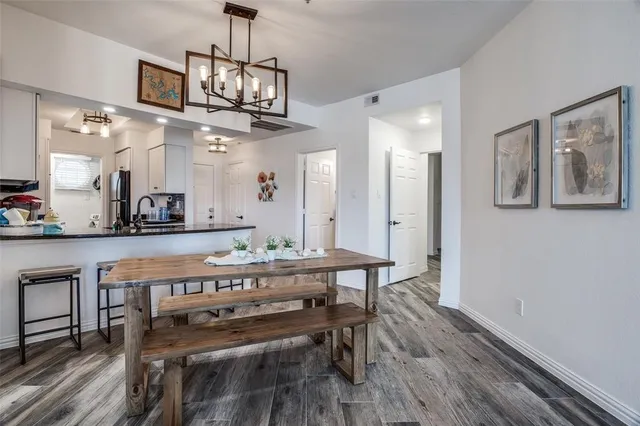 a view of a dining room with furniture a chandelier and wooden floor