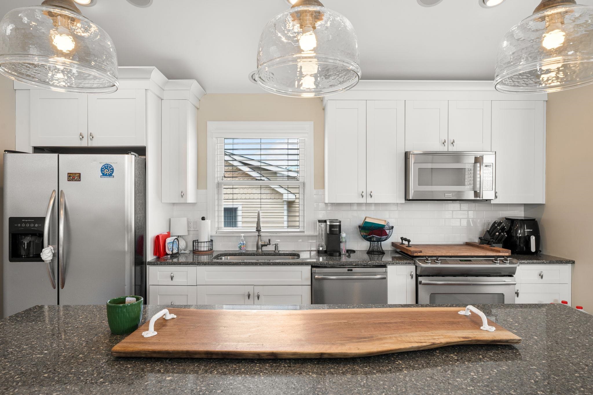 147 43rd Street Sea Isle City, NJ 08243 - Photo 13 of 50 a kitchen with stainless steel appliances granite countertop a refrigerator a sink dishwasher a stove and white cabinets