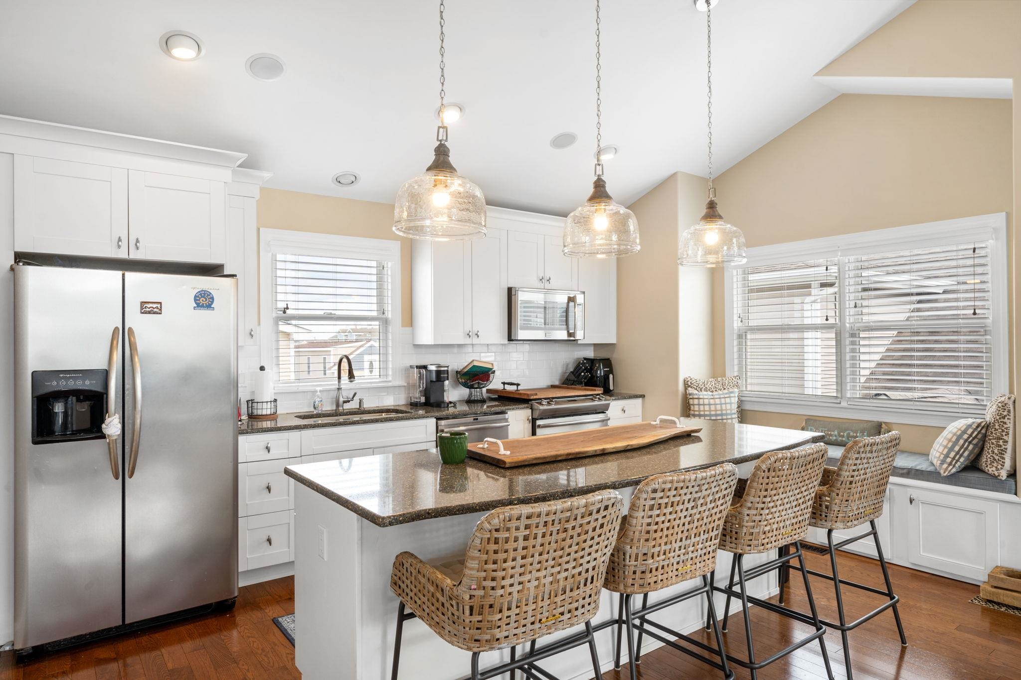 147 43rd Street Sea Isle City, NJ 08243 - Photo 14 of 50 a kitchen with granite countertop a sink a center island stainless steel appliances and cabinets