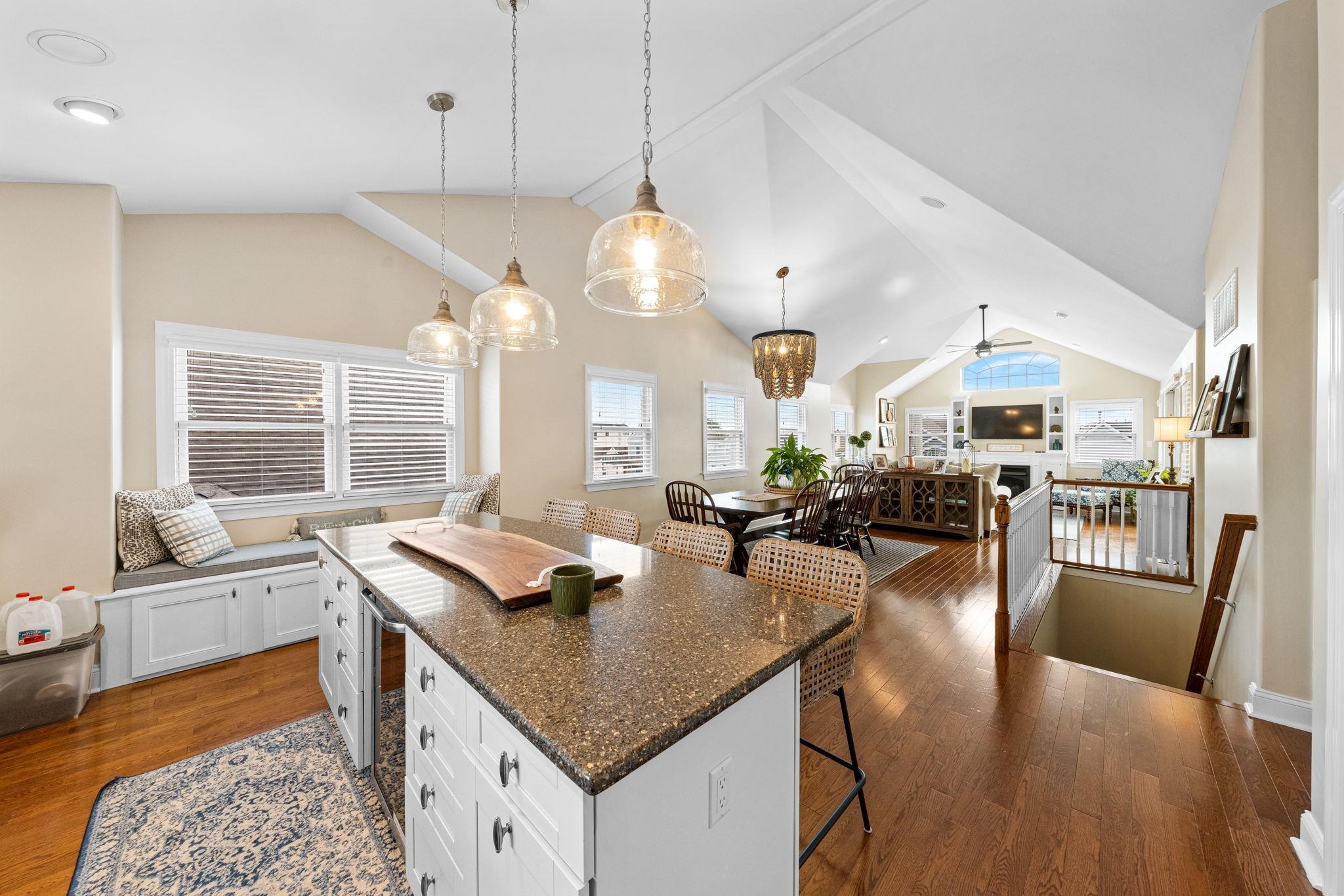 147 43rd Street Sea Isle City, NJ 08243 - Photo 21 of 50 a kitchen with a stove a sink dishwasher and a dining table with wooden floor