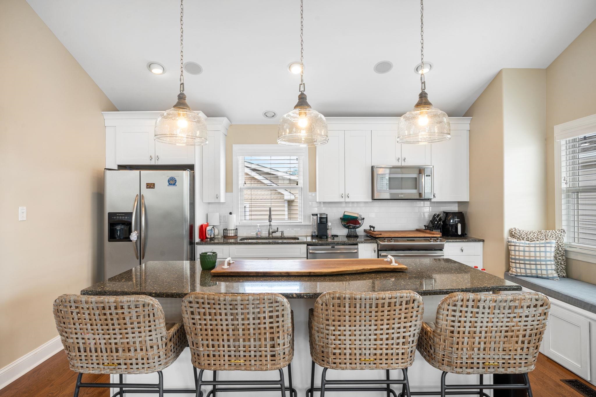 147 43rd Street Sea Isle City, NJ 08243 - Photo 3 of 50 a kitchen with stainless steel appliances granite countertop a sink a stove a refrigerator a dining table and chairs