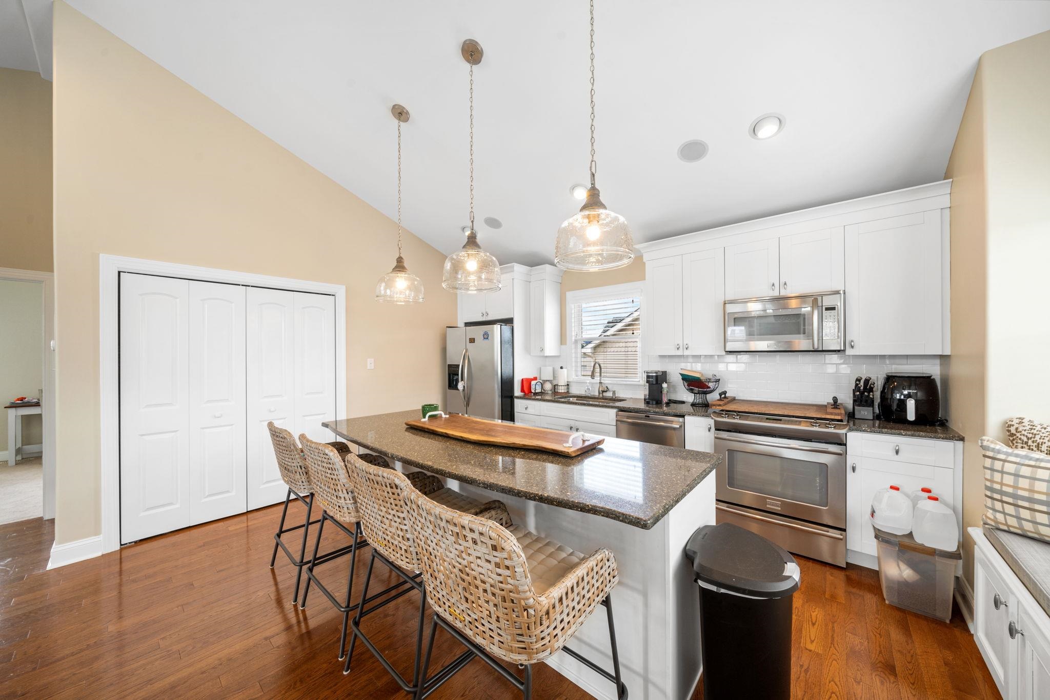 147 43rd Street Sea Isle City, NJ 08243 - Photo 34 of 50 a kitchen with kitchen island a stove a table and chairs in it