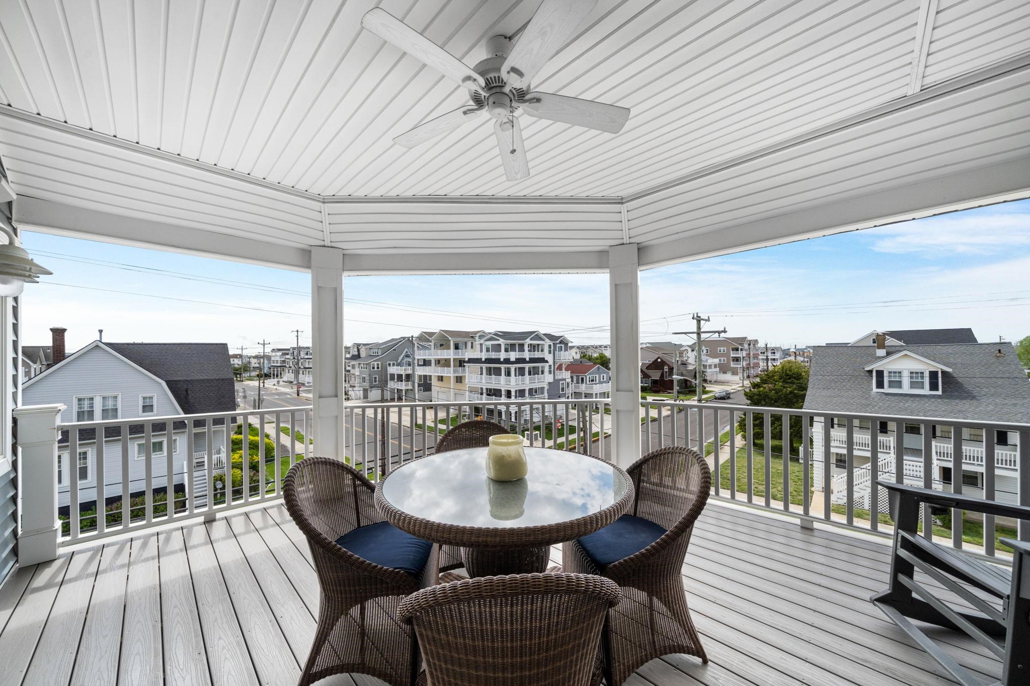 147 43rd Street Sea Isle City, NJ 08243 - Photo 5 of 50 a balcony with wooden floor table and chairs