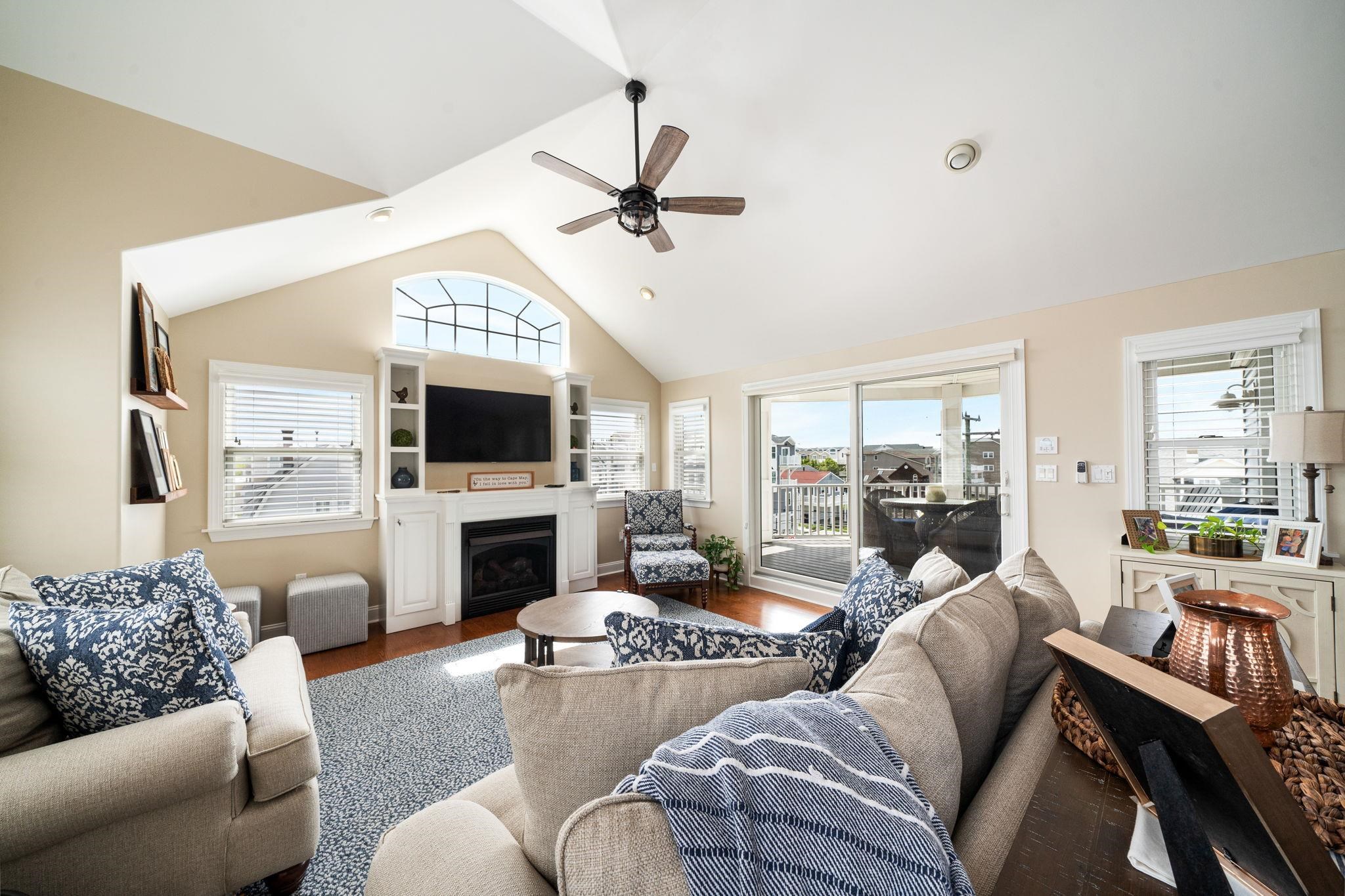 147 43rd Street Sea Isle City, NJ 08243 - Photo 6 of 50 a living room with furniture a flat screen tv and a fireplace