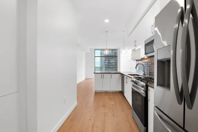a kitchen with stainless steel appliances granite countertop a sink a stove and refrigerator