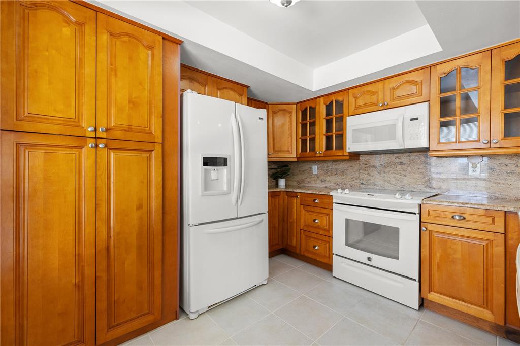 9000 Commodore Drive, Unit 604 Seminole, FL 33776 - Photo 11 of 50 a kitchen with stainless steel appliances granite countertop a refrigerator a washer and dryer