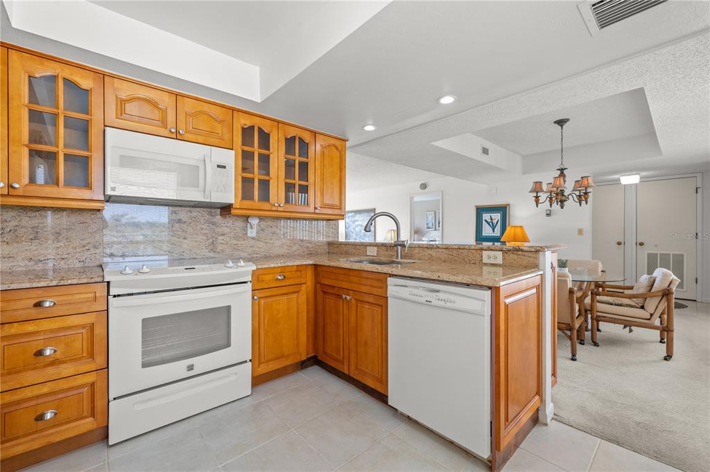 9000 Commodore Drive, Unit 604 Seminole, FL 33776 - Photo 13 of 50 a kitchen that has a lot of cabinets in it and wooden cabinets