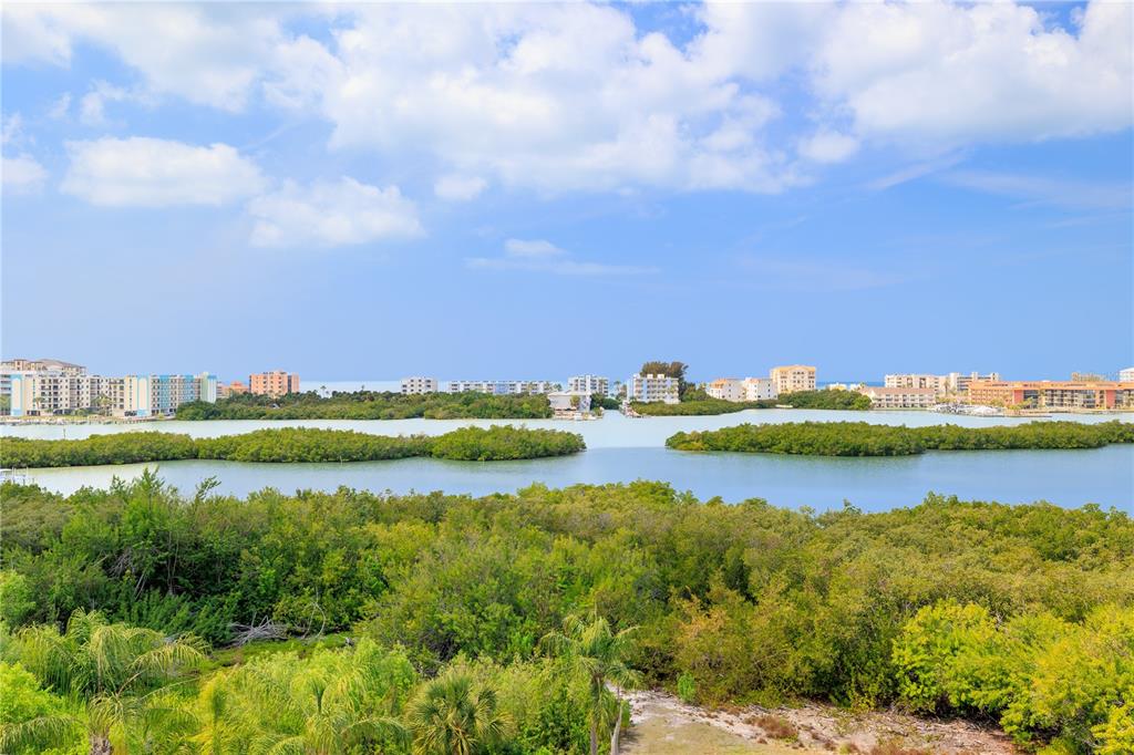 9000 Commodore Drive, Unit 604 Seminole, FL 33776 - Photo 31 of 50 a view of a lake with houses in the back
