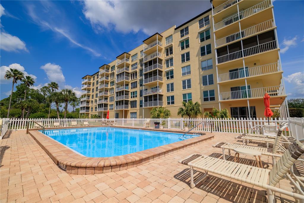 9000 Commodore Drive, Unit 604 Seminole, FL 33776 - Photo 34 of 50 a view of a swimming pool with a lounge chair