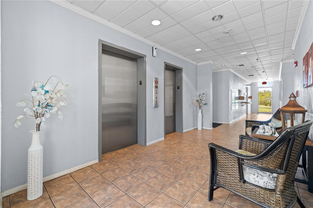 9000 Commodore Drive, Unit 604 Seminole, FL 33776 - Photo 47 of 50 a view of a hallway with furniture and a potted plant
