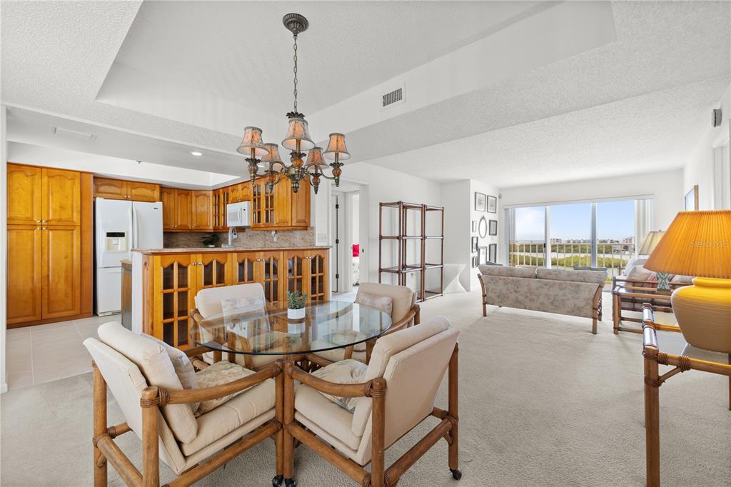 9000 Commodore Drive, Unit 604 Seminole, FL 33776 - Photo 5 of 50 a dining room with furniture a chandelier and window