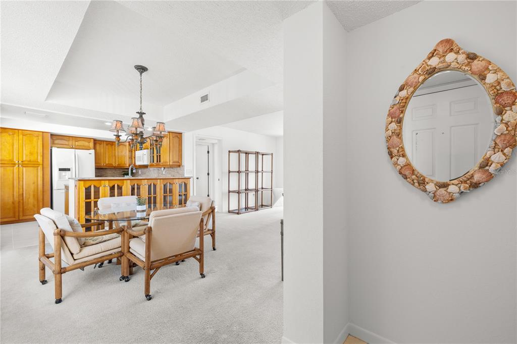 9000 Commodore Drive, Unit 604 Seminole, FL 33776 - Photo 9 of 50 a living room with furniture and a chandelier