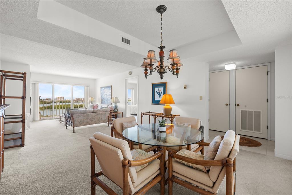 9000 Commodore Drive, Unit 604 Seminole, FL 33776 - Photo 10 of 50 a living room with furniture and a chandelier