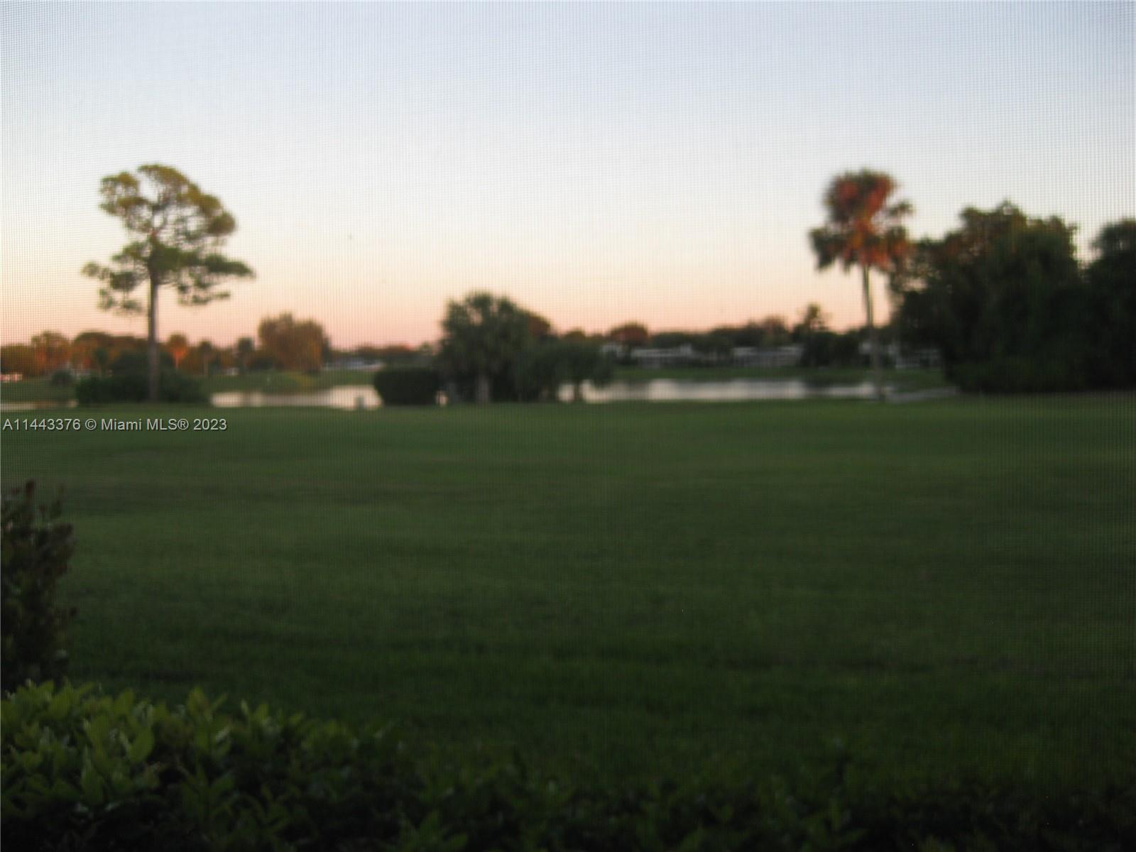 801 Pinecrest Circle, Unit E Jupiter, FL 33458 - Photo 16 of 18 a view of a golf course with a lake
