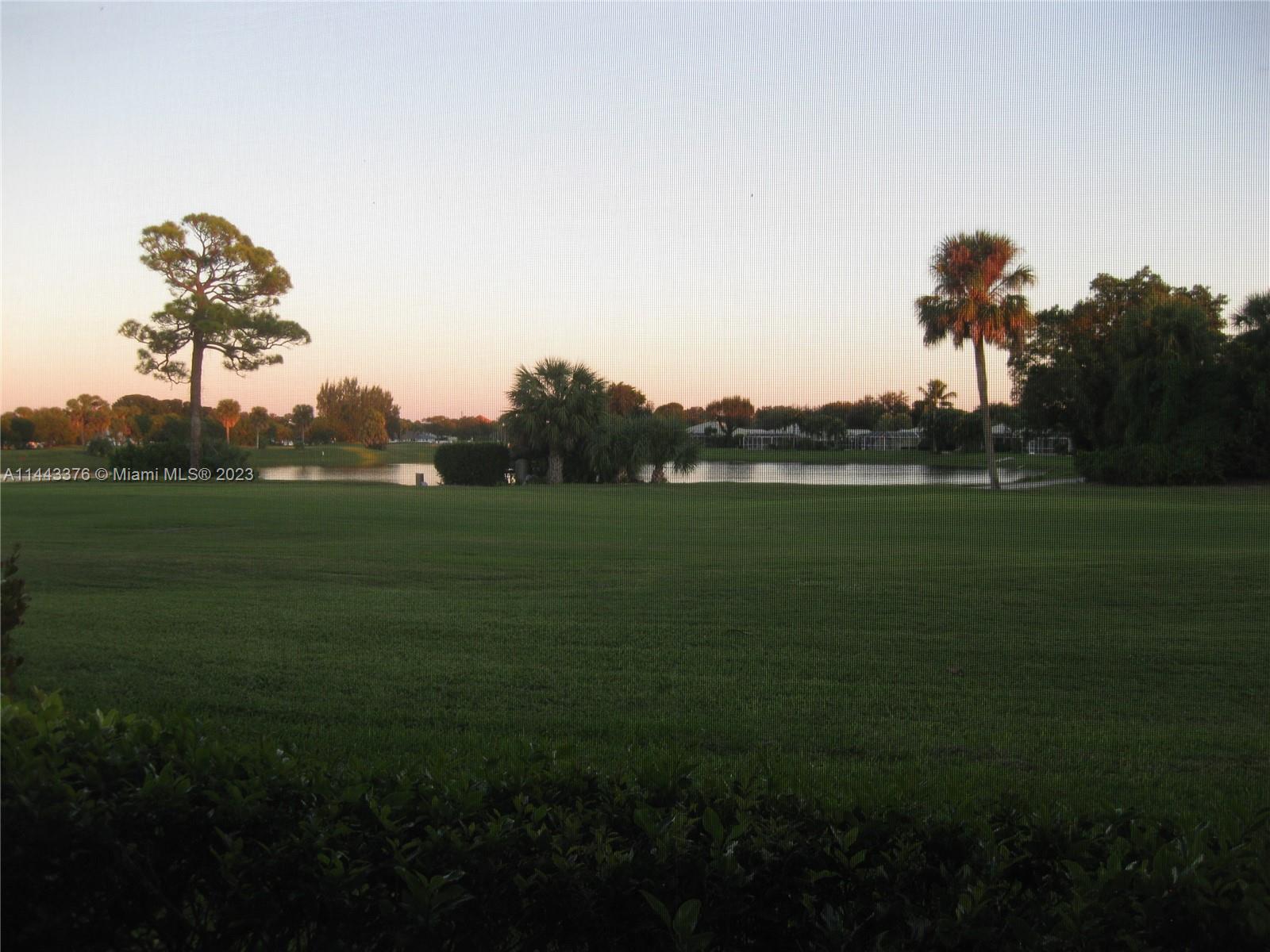 801 Pinecrest Circle, Unit E Jupiter, FL 33458 - Photo 17 of 18 a view of a golf course with a lake