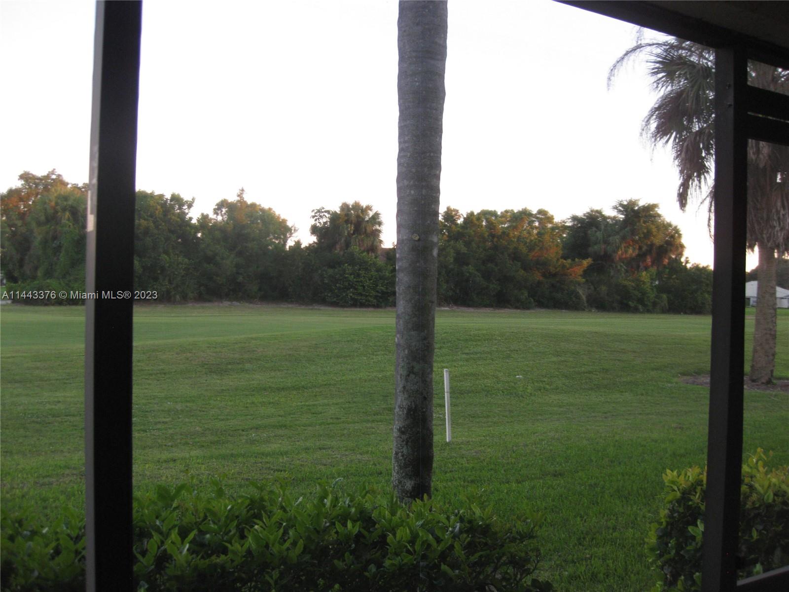 801 Pinecrest Circle, Unit E Jupiter, FL 33458 - Photo 18 of 18 a view of a field with a tree in the background