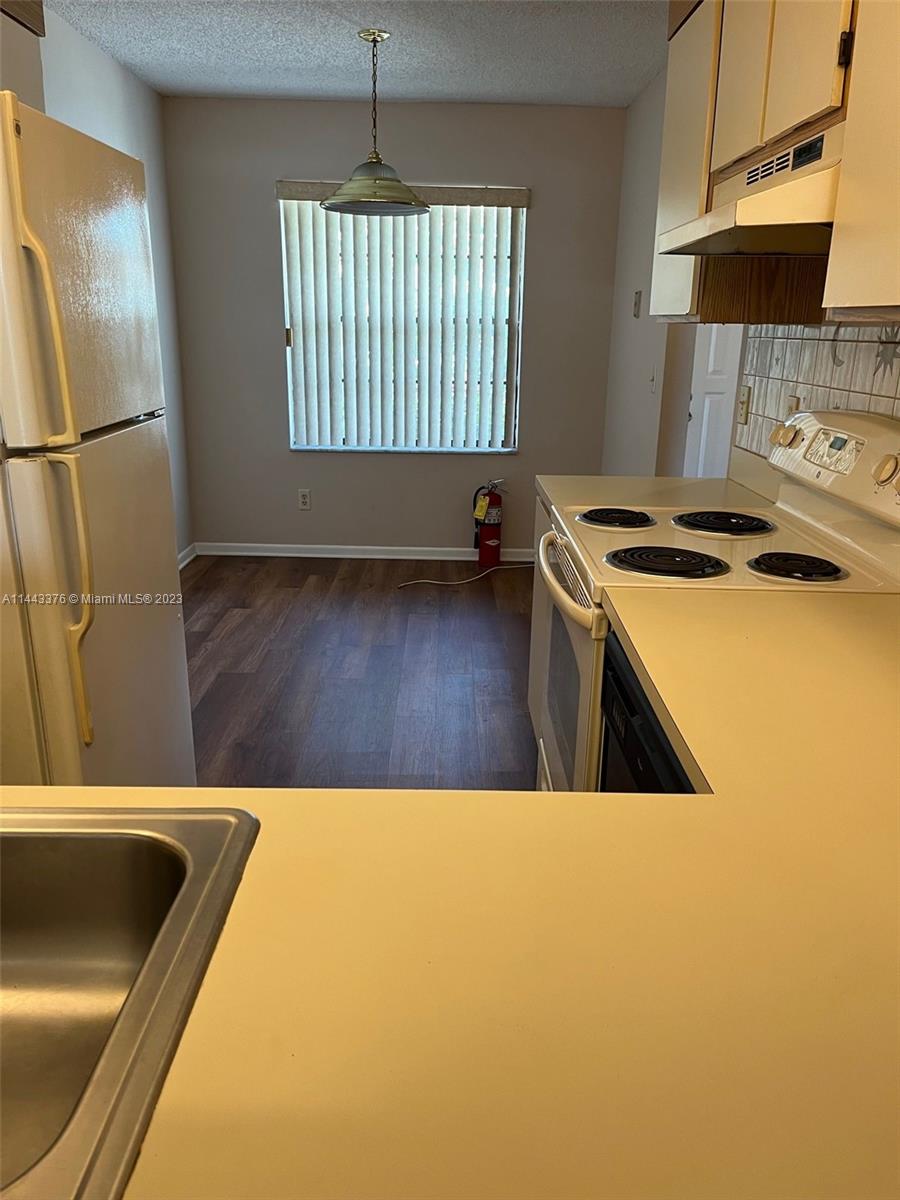 801 Pinecrest Circle, Unit E Jupiter, FL 33458 - Photo 3 of 18 a kitchen with a sink a stove and a refrigerator