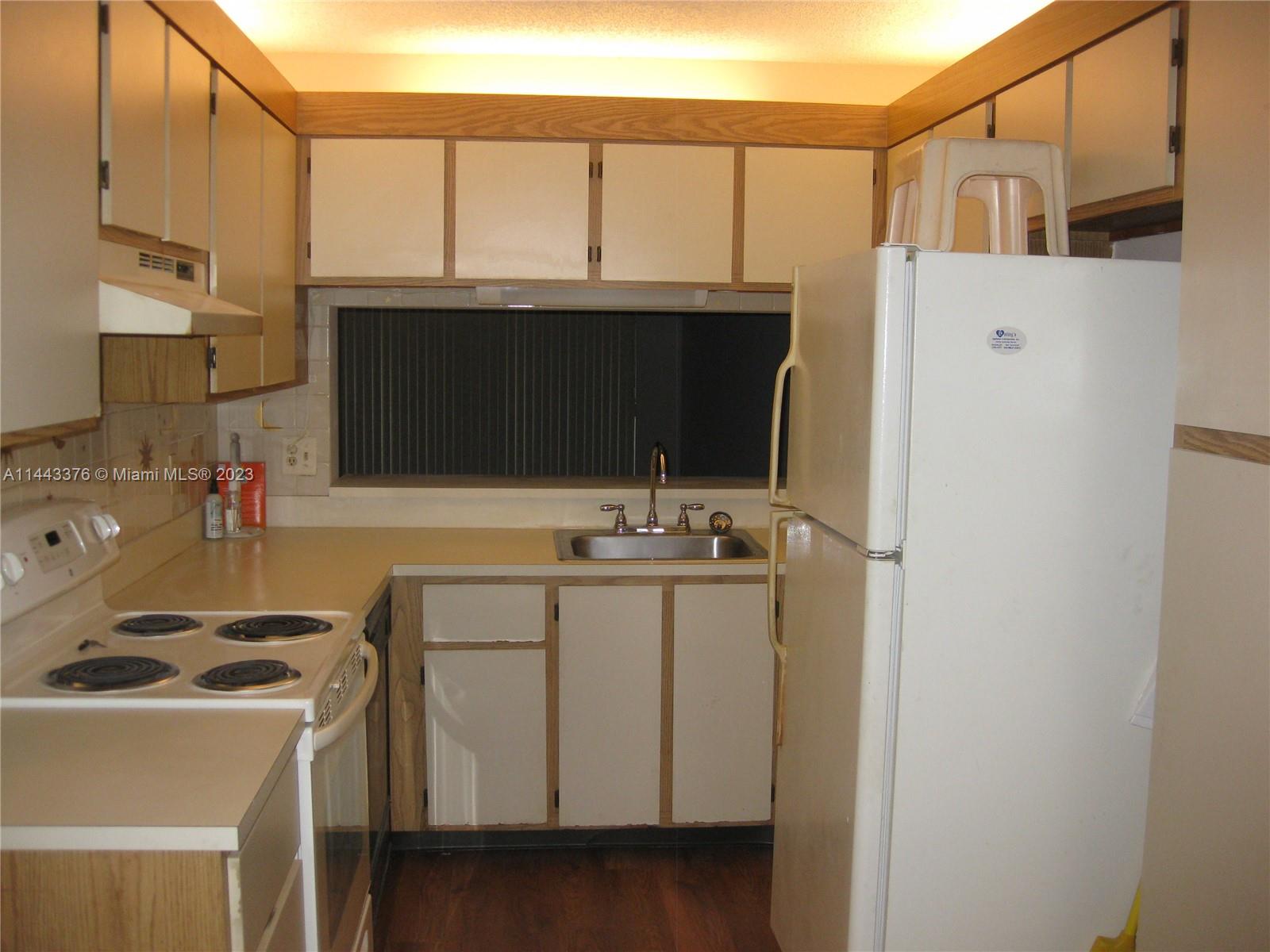 801 Pinecrest Circle, Unit E Jupiter, FL 33458 - Photo 8 of 18 a kitchen with a sink a stove and a microwave