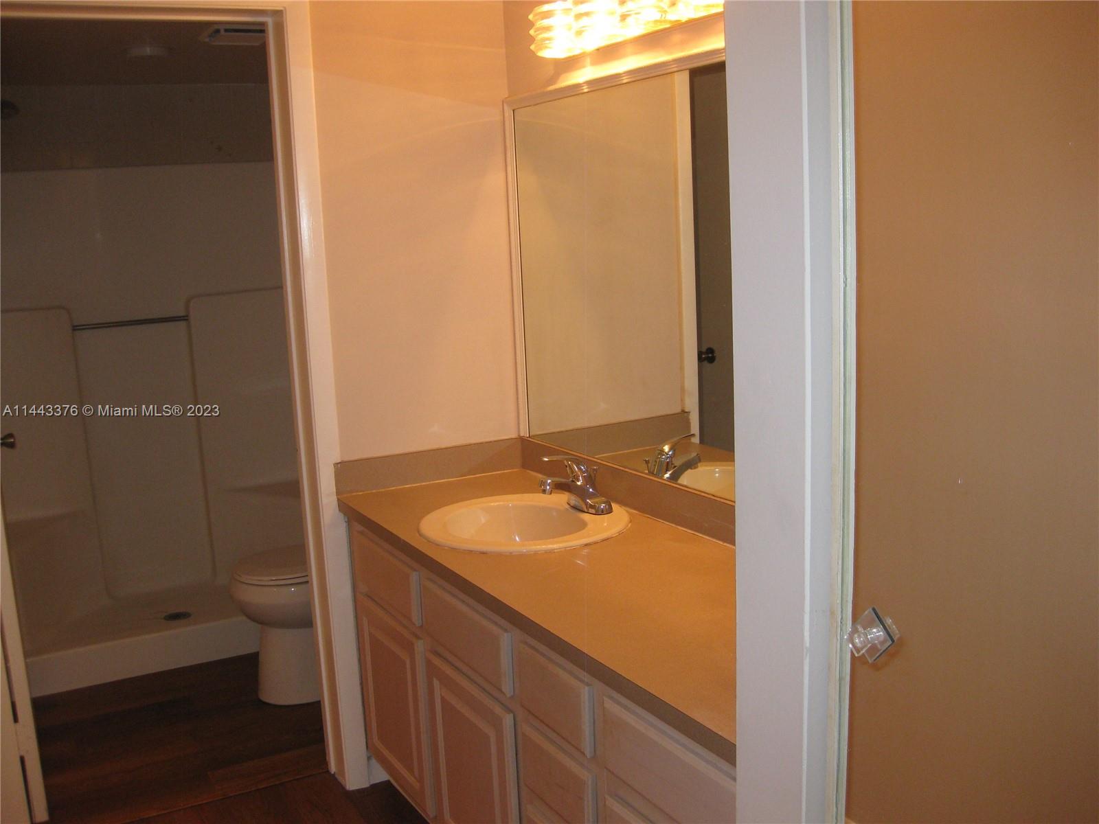 801 Pinecrest Circle, Unit E Jupiter, FL 33458 - Photo 9 of 18 a bathroom with a granite countertop sink toilet and shower