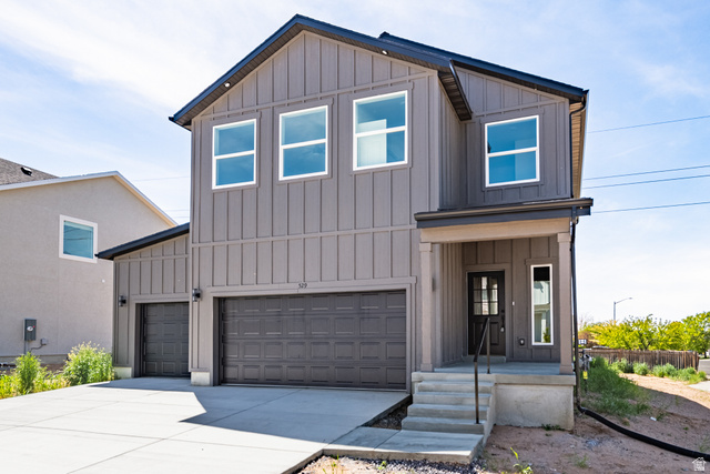529 North Hvn Drive Mapleton, UT 84664 - Photo 3 of 30 Contemporary two-story residence featuring vertical panel siding, a two-car garage, and a covered entryway