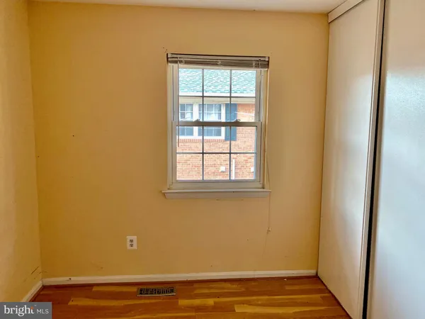 a view of a room with wooden floor and a window