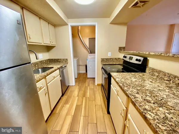 a kitchen with granite countertop wooden cabinets and a stove top oven