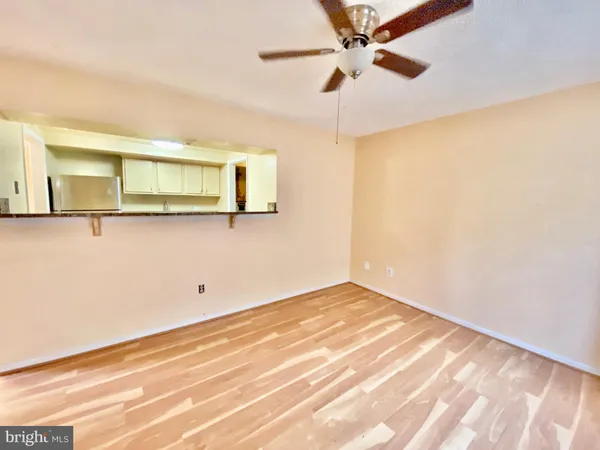 a view of a room with wooden floor and a ceiling fan