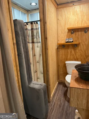 a bathroom with a sink a toilet and shower curtain