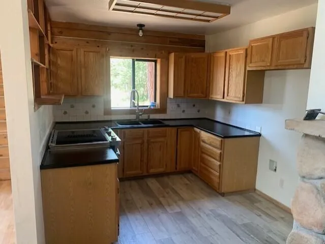 a kitchen with a sink a stove and cabinets