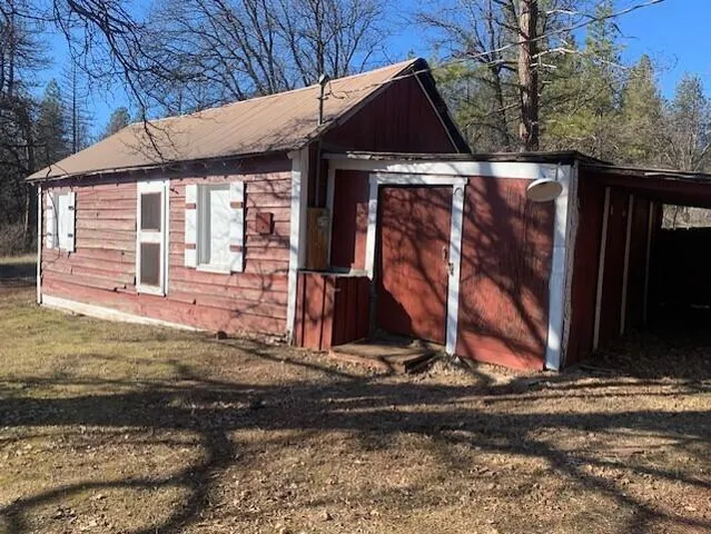 a view of a house with wooden fence next to a road