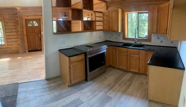 a kitchen with granite countertop a stove a sink and a microwave