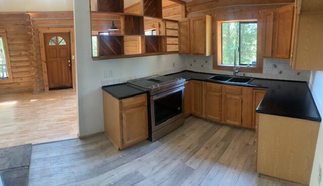 20394 Camas Road Burney, CA 96013 - Photo 5 of 56 a kitchen with granite countertop a stove a sink and a microwave