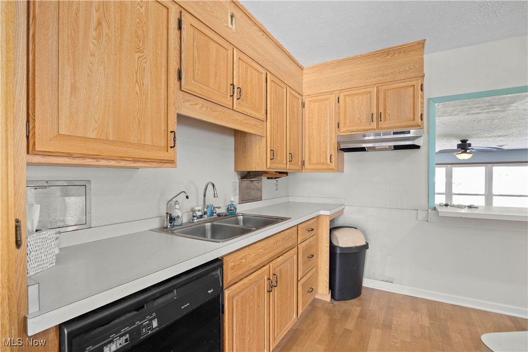 14015 West Lake Road Vermilion, OH 44089 - Photo 19 of 50 Kitchen featuring dishwasher, a textured ceiling, light brown cabinets, light countertops, and light wood finished floors