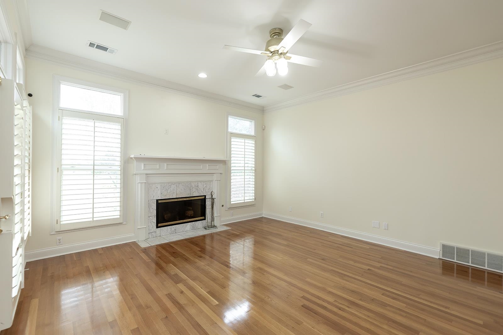 9390 Mayfield Road South Collierville, TN 38017 - Photo 16 of 40 Unfurnished living room featuring ornamental molding, a high end fireplace, wood finished floors, and ceiling fan