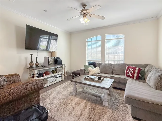 a living room with furniture a flat screen tv and a window