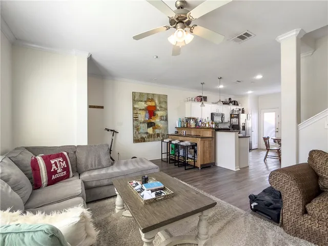 a living room with furniture kitchen view and a chandelier