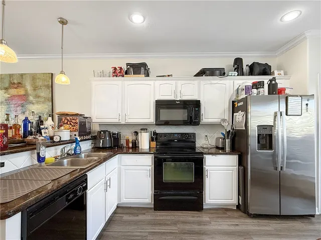 a kitchen with stainless steel appliances a stove a sink and a refrigerator