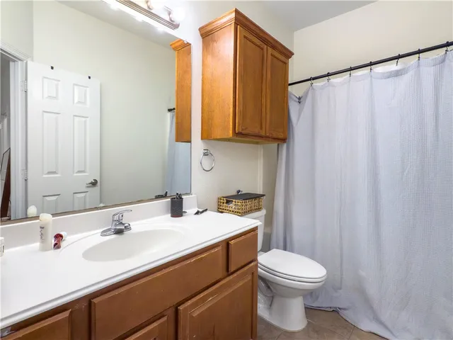 a bathroom with a sink a toilet and shower curtain