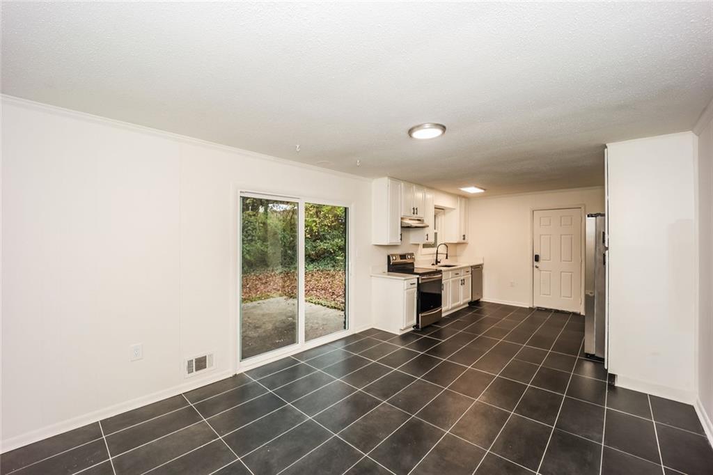5726 Southwick Court Southwest Atlanta, GA 30349 - Photo 11 of 31 a large white kitchen with cabinets a sink and a stainless steel appliances