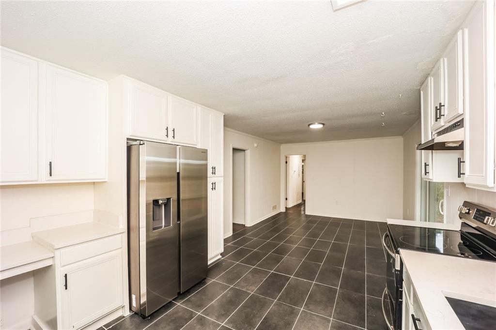 5726 Southwick Court Southwest Atlanta, GA 30349 - Photo 16 of 31 a kitchen with granite countertop a refrigerator and a stove