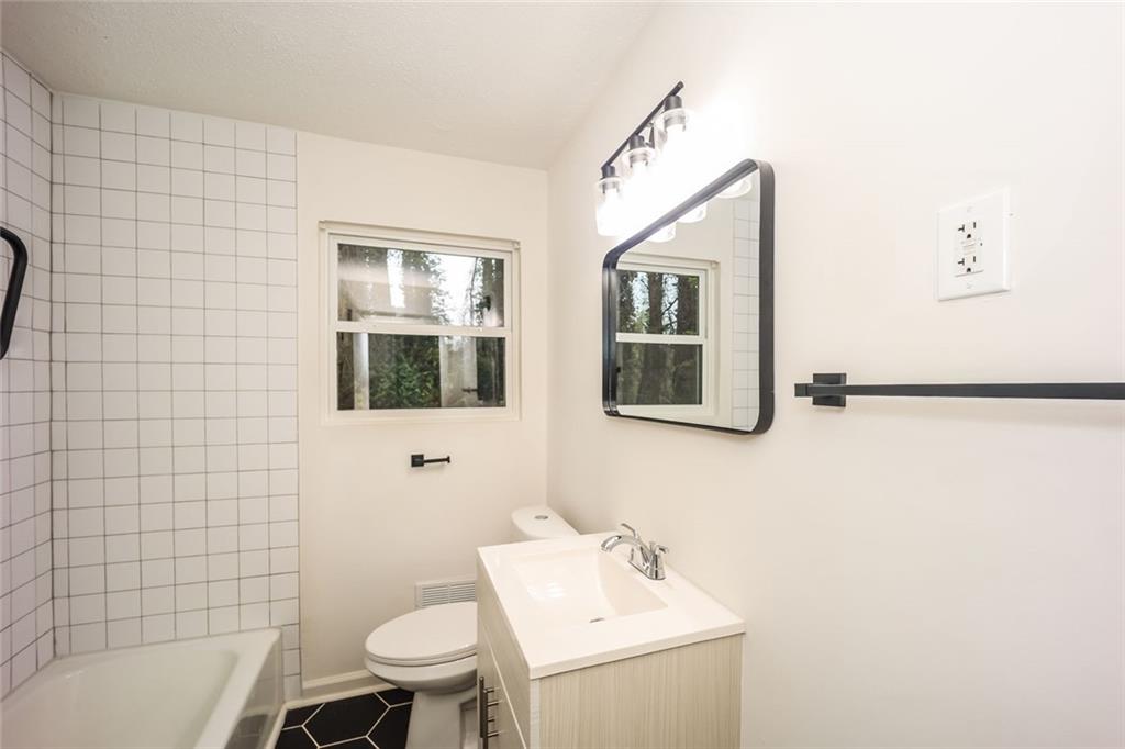5726 Southwick Court Southwest Atlanta, GA 30349 - Photo 22 of 31 a bathroom with a sink mirror toilet and bathtub