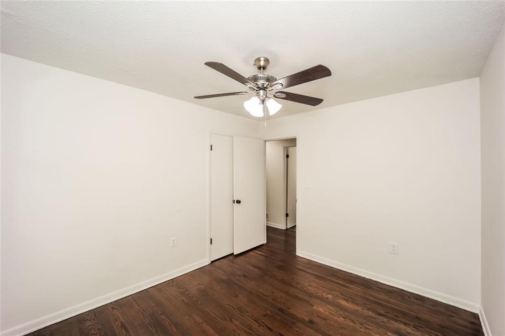 5726 Southwick Court Southwest Atlanta, GA 30349 - Photo 28 of 32 an empty room with wooden floor and ceiling fan