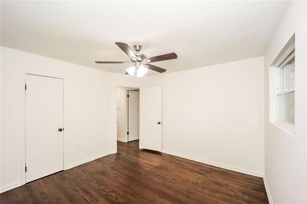 5726 Southwick Court Southwest Atlanta, GA 30349 - Photo 4 of 31 an empty room with wooden floor fan and windows