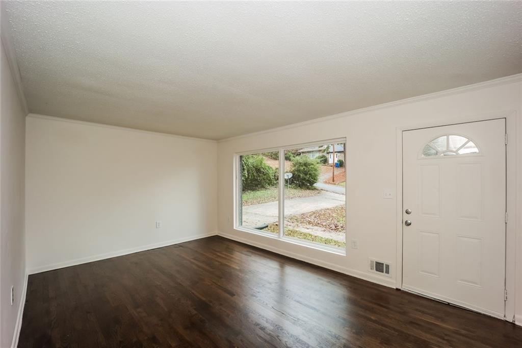 5726 Southwick Court Southwest Atlanta, GA 30349 - Photo 6 of 32 an empty room with wooden floor and windows