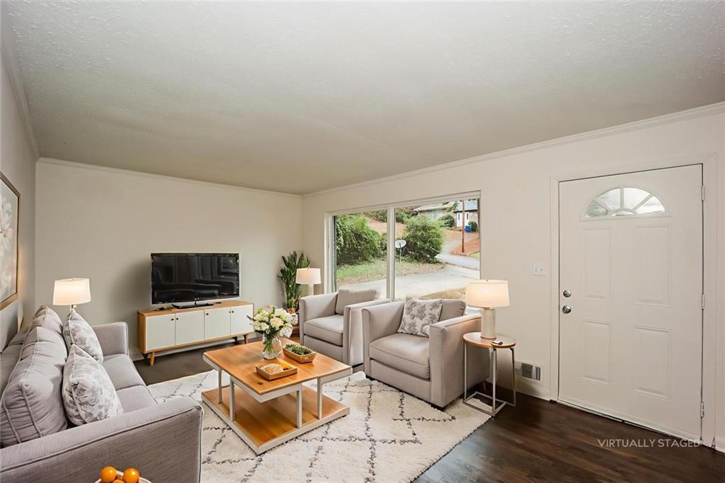 5726 Southwick Court Southwest Atlanta, GA 30349 - Photo 7 of 31 a living room with furniture a flat screen tv and a window