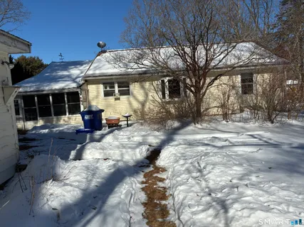 a view of a house with a yard covered with snow in the background