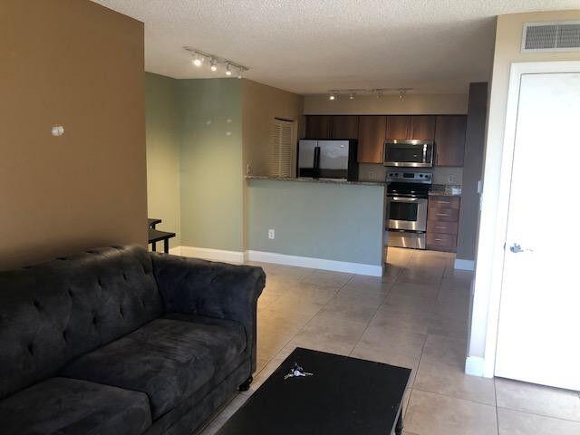 1000 Crystal Way, Unit C Delray Beach, FL 33444 - Photo 3 of 10 a living room with furniture and a flat screen tv